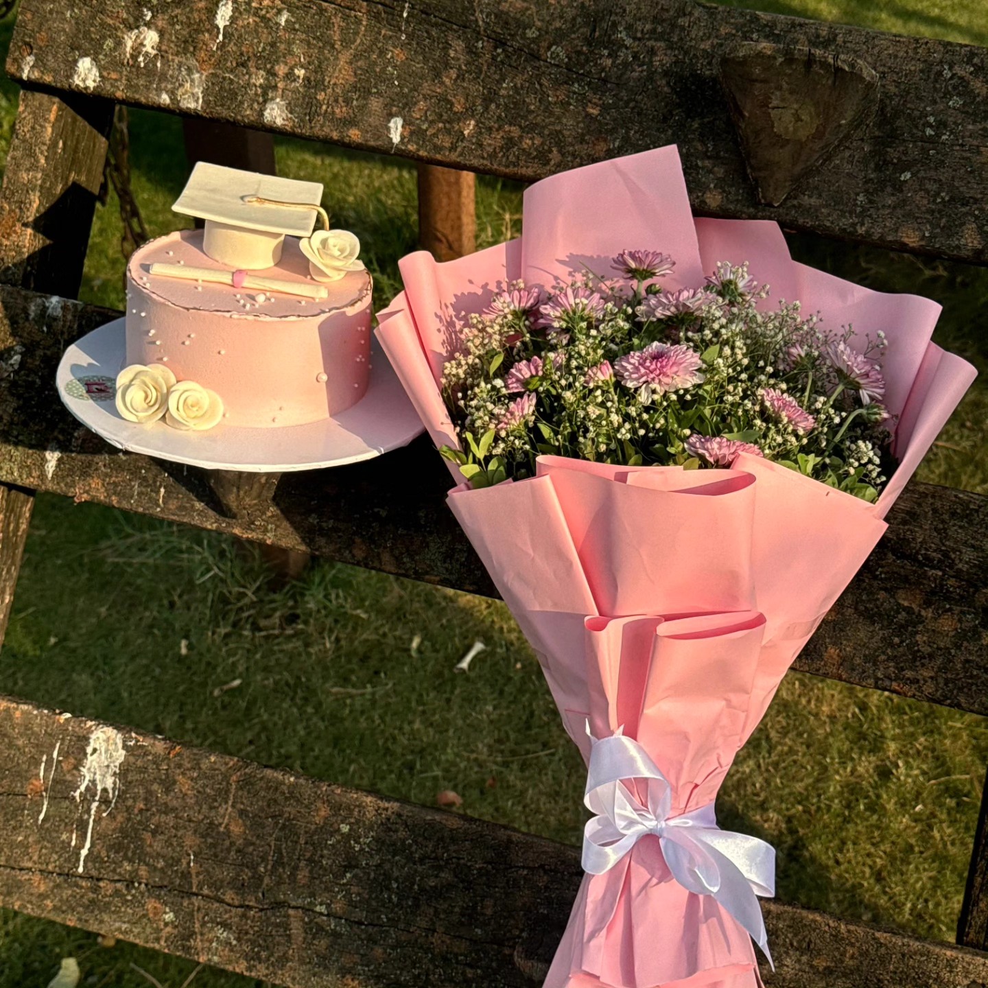 Pink graduation cake and bouquet